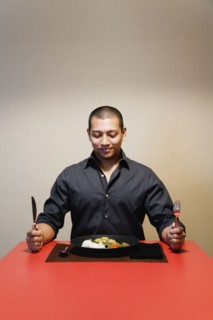 Asian man at table with full plate of food