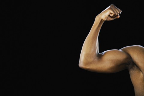 Studio shot of African man flexing biceps