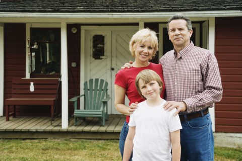 Portrait of family in front of house