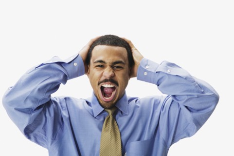 African businessman yelling with hands on head