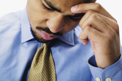 Close up of African businessman with head in hand