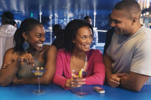 Three African friends laughing at bar