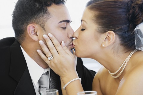 Multi-ethnic bride and groom kissing