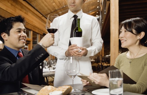 Asian man testing wine at restaurant