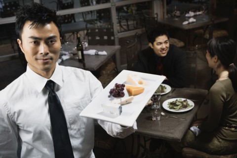 Asian waiter carrying plate of food