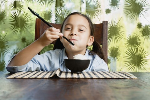 Asian girl eating bowl of rice