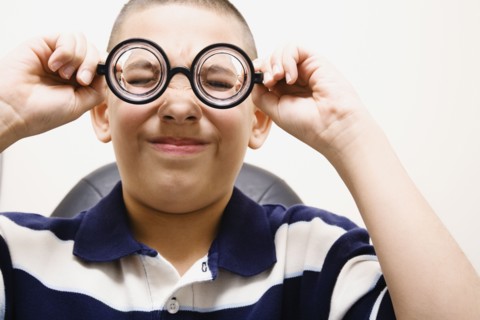 Asian boy taking off eye glasses