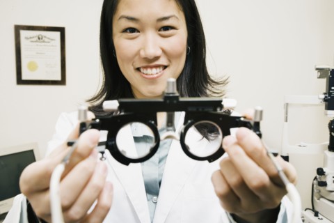 Asian female optometrist holding equipment