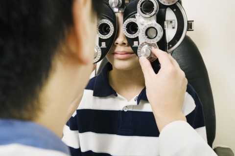 Asian male optometrist examining patient