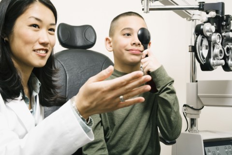 Asian female optometrist examining patient