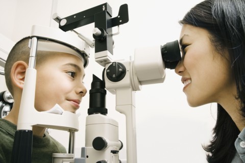 Asian female optometrist examining patient