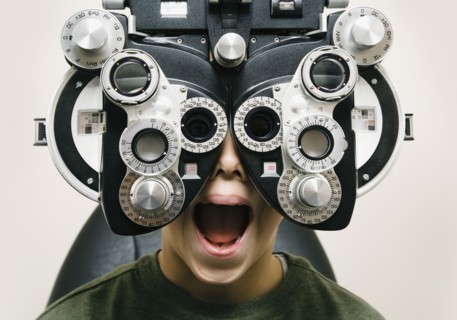 Asian boy having eyes examined