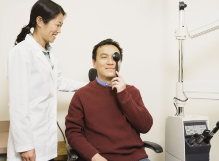 Asian female optometrist examining patient