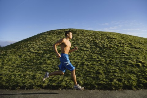 Bare chested Asian man jogging