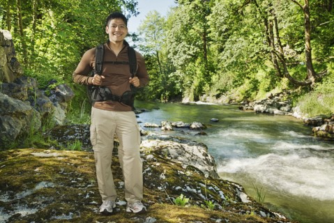 Mixed race man hiking near river