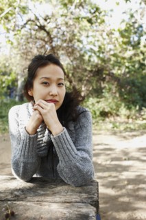 Asian woman sitting at picnic bench