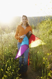 Hispanic woman holding kite outdoors