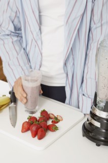 Asian man making fruit smoothie