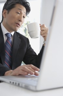 Asian businessman typing on laptop