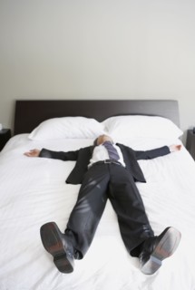 Asian businessman laying on bed