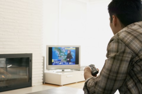 Asian man watching television