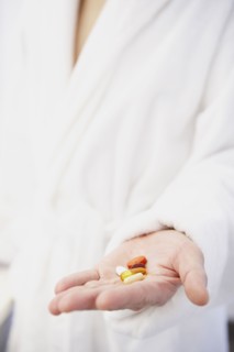 Asian man holding pills in hand