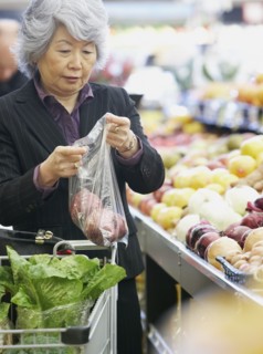 Senior Asian woman shopping for produce