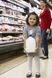 Indian girl carrying milk in grocery store