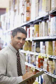 Hispanic grocery store manager holding clipboard