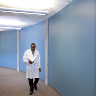 Mixed race doctor walking in hospital with medical chart