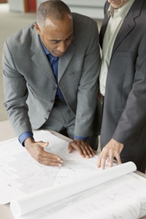 Businessmen looking at blueprints
