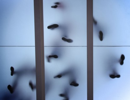 Silhouette of feet standing on glass ceiling