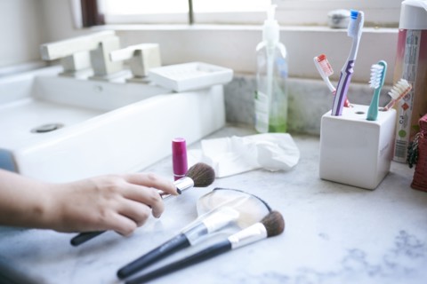 Hand of Hispanic woman holding makeup brush