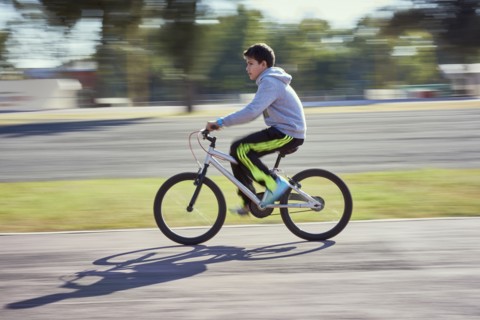 Hispanic boy riding bicycle
