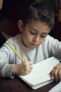 Hispanic boy practicing writing alphabet