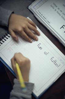 Hispanic boy practicing writing alphabet