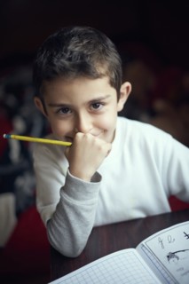Smiling Hispanic boy practicing writing alphabet