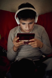 Hispanic boy listening to cell phone with headphones