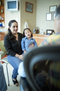 Hispanic mother and daughter with Down Syndrome talking to doctor
