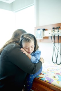 Hispanic mother hugging daughter with Down Syndrome