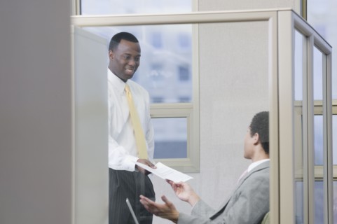 Multi-ethnic businessmen holding paperwork in office