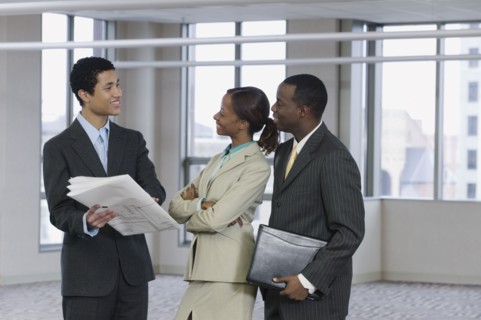 Multi-ethnic business people reviewing blueprints