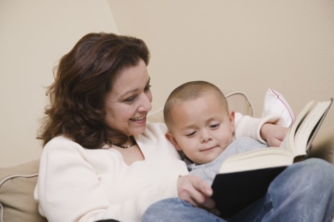 Multi-ethnic grandmother and grandson reading book