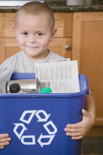 Hispanic boy holding recycling bin