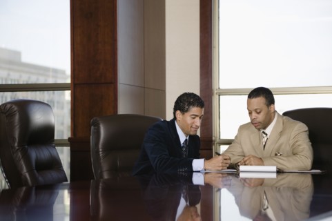 Two businessmen working in executive conference room