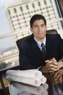 Mixed race businessman with blueprints