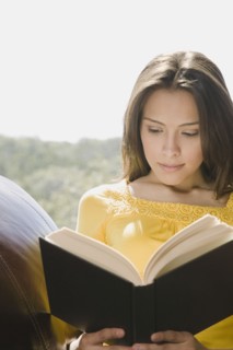 Hispanic woman reading book