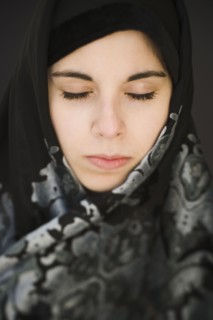 Middle Eastern teenager in headscarf with eyes closed