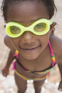 Smiling African girl wearing goggles and bikini