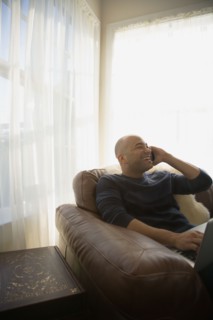 Mixed race man talking on cell phone in living room